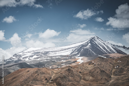Mountain landscape with a view of a rocky ridge with snow and glaciers in the highlands of Tajikistan in the Pamirs. A panorama of the Tien Shan Mountains for background