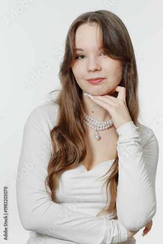 Portrait of a smiling young girl wearing pearl jewelry.