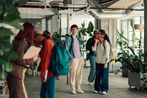 Canvas Print Diverse students walking through a modern university campus building, learning a