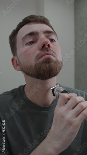 White man shaping neckline along jaw, steady wrist motion with trimmer, mirror reflection, neat grooming routine and composed