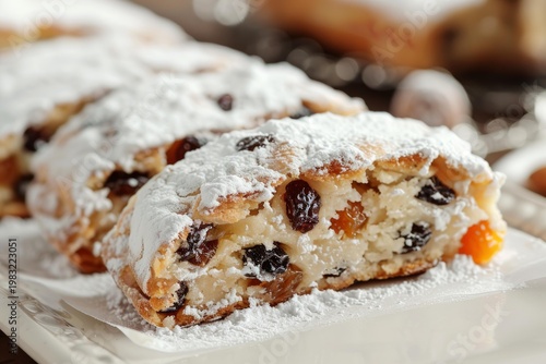 Close up of slices of christmas stollen, a traditional german fruitcake, resting on a serving platter and generously dusted with powdered sugar