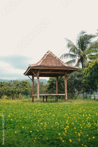 Cuadro en lienzo Traditional wooden gazebo in lush green tropical garden setting