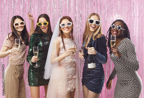 Tableau sur toile Happy fashionable young women posing with glass of champagne during hen or bache