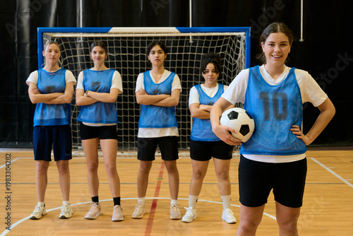 Canvas Print Female soccer team posing together on indoor court