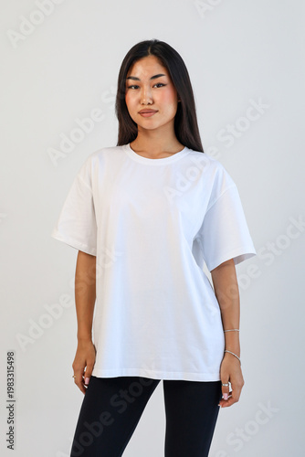 Female model standing straight with white Tshirt against neutral background for catalog display