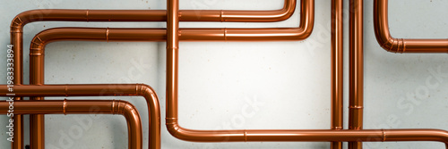 Obraz na płótnie Polished copper pipes arranged in a complex network against a textured wall