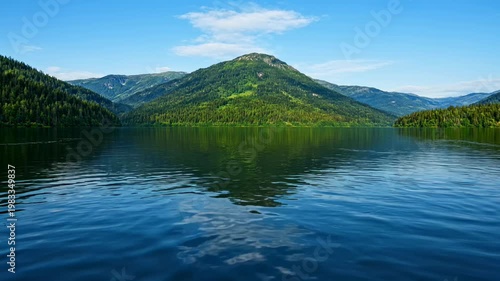 The images capture a tranquil scene of a large lake situated amidst lush green mountains