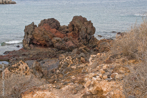 Bild auf Leinwand rocky shrubland on the coast of the calm blue Atlantic ocean in Tenerife, Canary