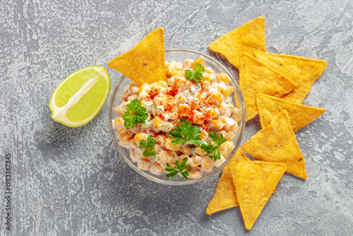 Mexican street corn dip in bowl. Elote dip with nachos chips. Latin American cuisine. Top view
