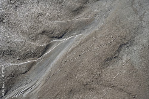 Abstract Nature Background Texture of Wet Grey Mud with Fine Cracks, Close Up Minimalist Top View of Textured Slime Clay and Earth Soil Pattern formed by Water Flow