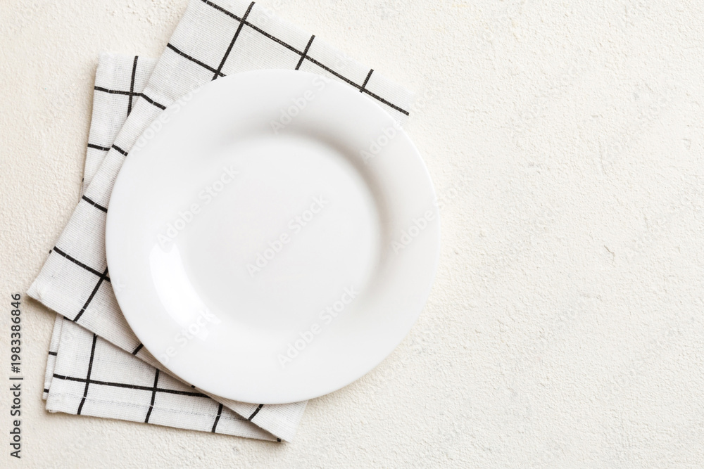 Naklejka premium Top view on colored background empty round white plate on tablecloth for food. Empty dish on napkin with space for your design