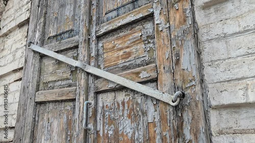 A shuttered window of an abandoned dilapidated house