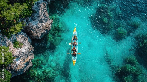Kayaking trio on turquoise water near rocky coast, aerial view, summer adventure