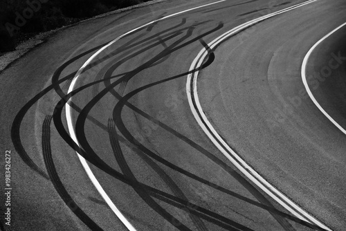 Road with Curve or Turn Double Lines and Skid Marks from Tire Tracks on Asphalt