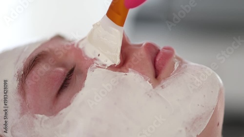 Aesthetician carefully applies an even layer of clay mask to the client's face, providing deep cleansing and balancing for the skin