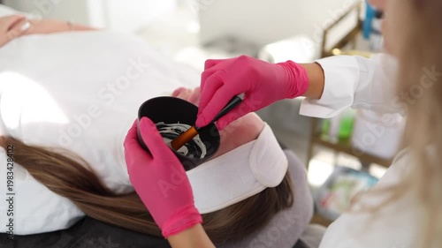 Skincare specialist distributes the clay mask thoroughly over the client's face, ensuring even coverage for a balanced complexion