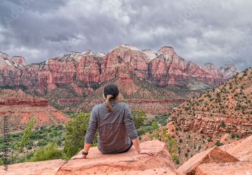 Φωτογραφία Woman sitting on a cliff looking out over Zion National Park