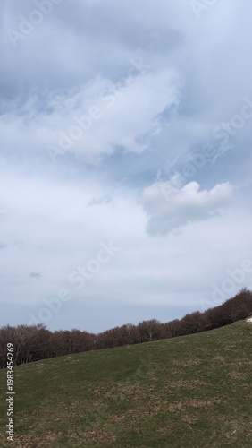 Vista da un sentiero di montagna, sotto un cielo coperto un paesaggio naturale maestoso.