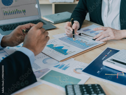 Business professionals are discussing charts and graphs that illustrate the results of teamwork; a brainstorming process for successful teamwork.