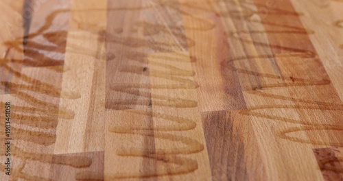 Laminated wood board finished with tung oil dispensed from a syringe