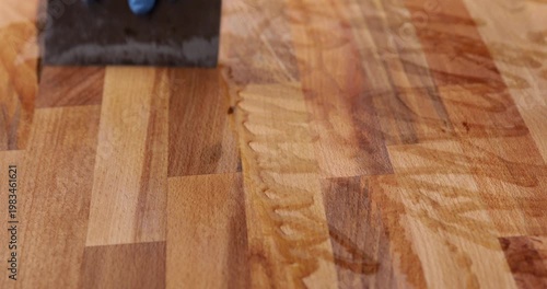 The laminated wood board is protected by tung oil, which was spread with a filler spatula