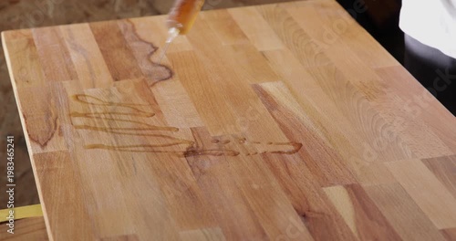 Laminated wood board finished with tung oil dispensed from a syringe