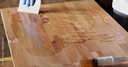The laminated wood board is protected by tung oil, which was spread with a filler spatula