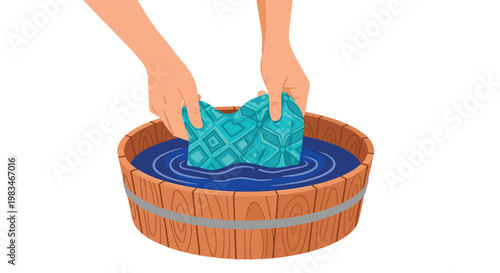 A pair of hands rinses a vibrant turquoise patterned fabric in a rustic wooden tub filled with dark blue water against a plain white background space.