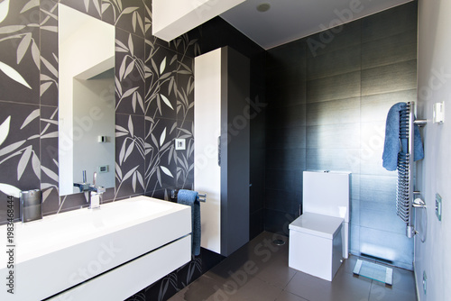 Modern bathroom interior displaying stylish grey and white design with bamboo leaf tiles