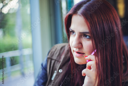 Concerned Young Woman With Red Hair On The Phone
