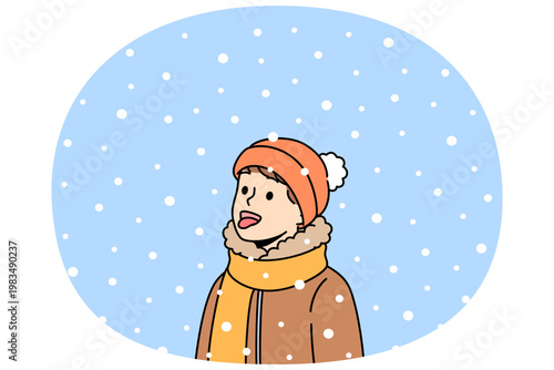 Boy opens mouth and eating snow, enjoying winter weather and new year mood. Christmas portrait of small child in scarf and warm hat, rejoicing with first snow or onset of winter holidays