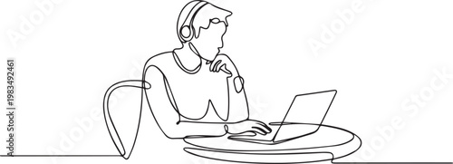 A person sitting at a table with a laptop and wearing headphones
