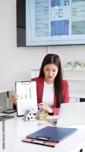Young asian woman real estate advisor talking with client online about monthly mortgage payment, sitting in front of laptop, female loan officer working remotely from office.


