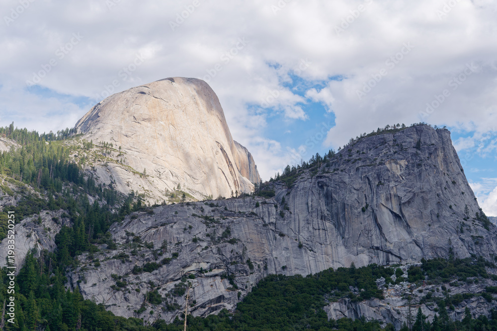 Obraz premium Iconic Half Dome and Liberty Cap granite peaks under a blue sky, Yosemite National Park, California, USA