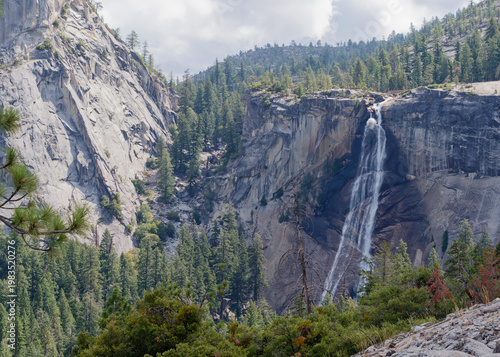 Vernal Fall waterfall cascading down granite cliffs surrounded by forest, Yosemite National Park, California, USA