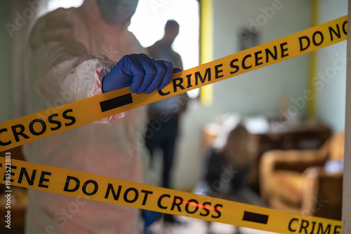 Принти на полотні Forensic investigator placing yellow crime scene do not cross tape at a location