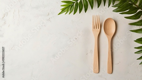 Wooden fork and spoon with green leaves, creating a natural and eco-friendly composition