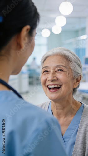 Happy Senior Asian Woman Patient Laughing with Nurse in Hospital Ward, Geriatric Healthcare and Medical Care Concept