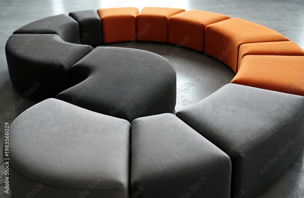 Fototapeta premium Curved modern modular seating in grey black and orange hues. Textured fabric upholstery forms a smooth sleek geometric shape. Arrangement for comfort in lounge interior decor.