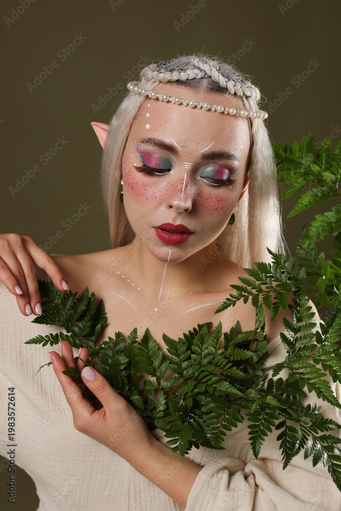 Fototapeta premium Beautiful elf girl with floral decor on dark olive background