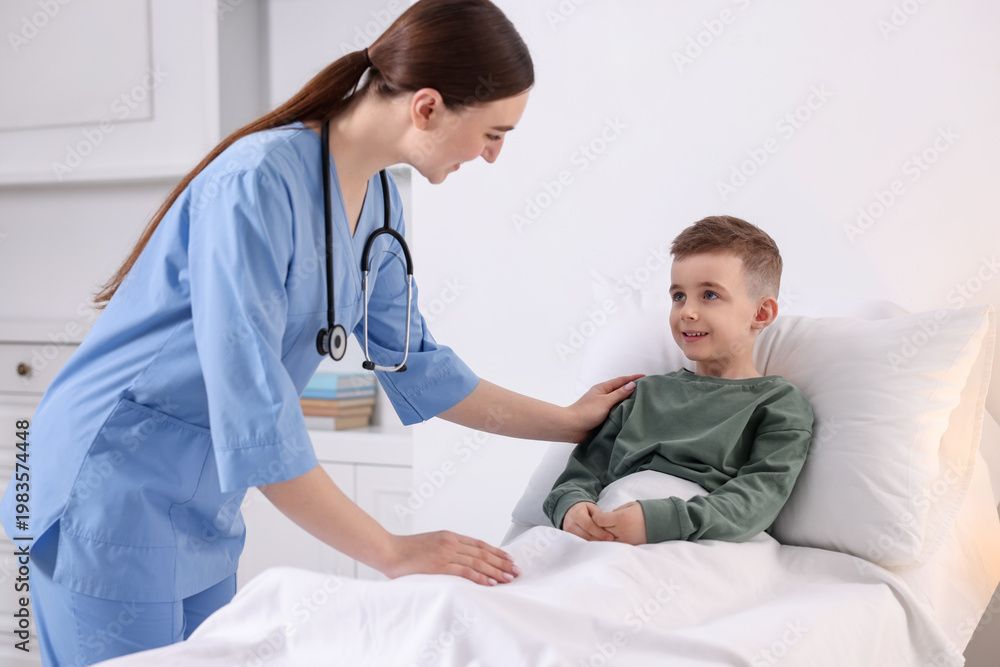 Fototapeta premium Doctor examining little child on bed in hospital