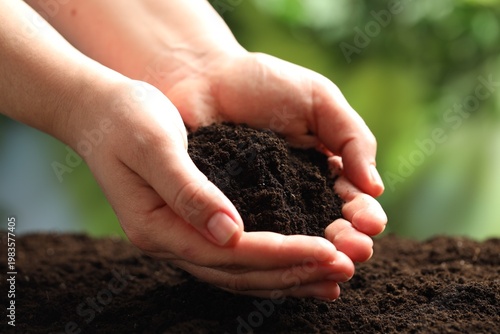 Woman with fresh soil on blurred background, closeup