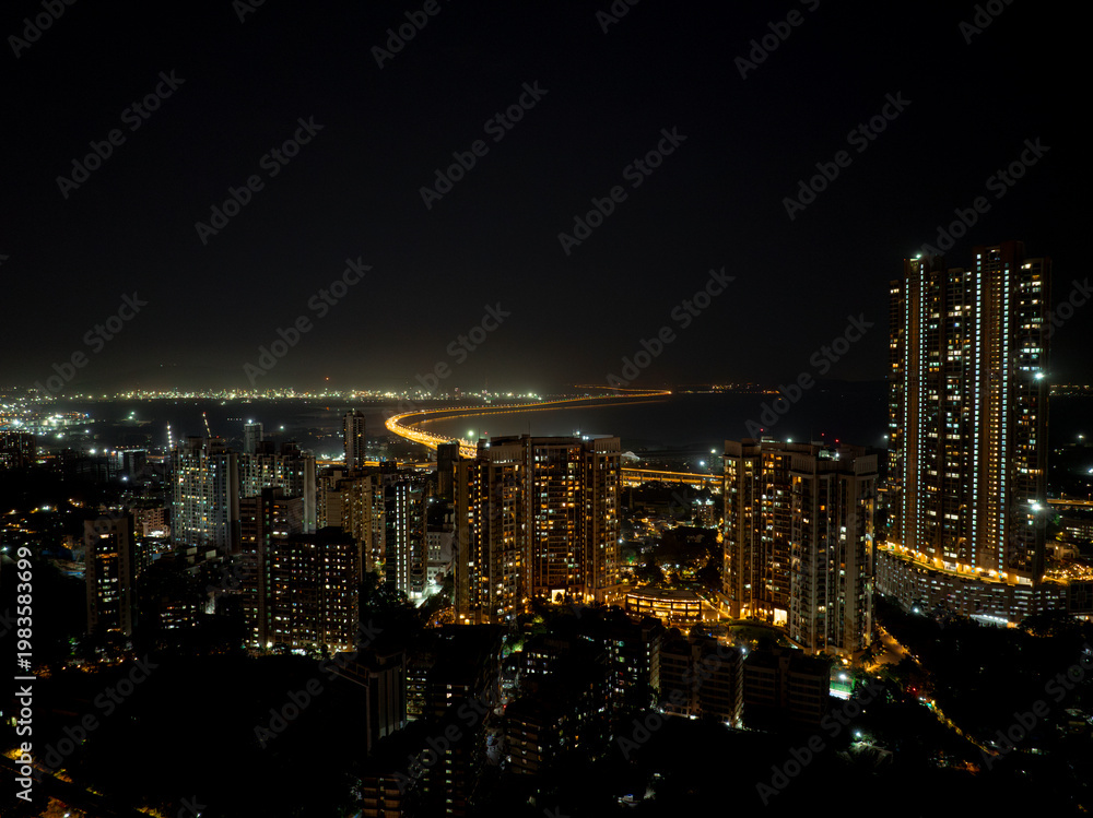 Obraz premium India's Longest Sea Bridge: Trans-Harbour Sea Link. Atal Setu sea bridge in Mumbai, Maharashtra, India. A city at night with bright skyscrapers and a dense network of glowing buildings.