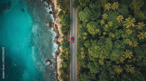 Aerial View of a Red Car Driving Along a Scenic Tropical Coastal Road Between Lush Jungle and Turquoise Ocean