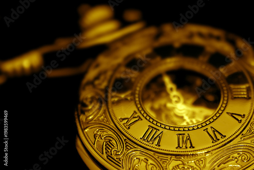 Antique old gold fob pocket watch on a black background backdrop. Classic vintage retro jewellery.