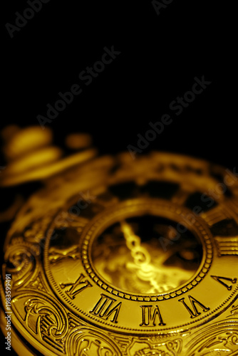 Antique old gold fob pocket watch on a black background backdrop. Classic vintage retro jewellery.