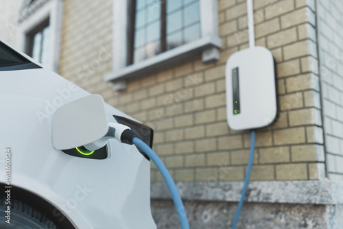 Electric vehicle charging at home station with wall charger, eco friendly transportation and renewable energy concept