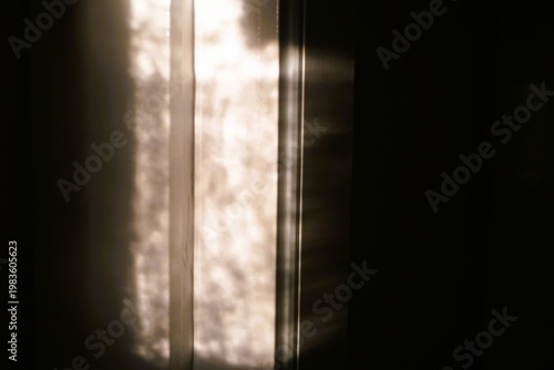 Abstraktes Motiv mit Lichtschattenmuster vor schwarzer Wand als Hintergrund