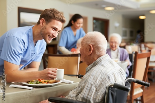Male Nurse Offering Coffee to a Senior Man in a Wheelchair