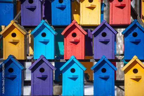A large number of birdhouses of different colors.